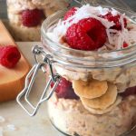 Raspberry Banana Overnight Oats layered with banana slices, raspberries, oats, and shredded coconut in a glass jar.